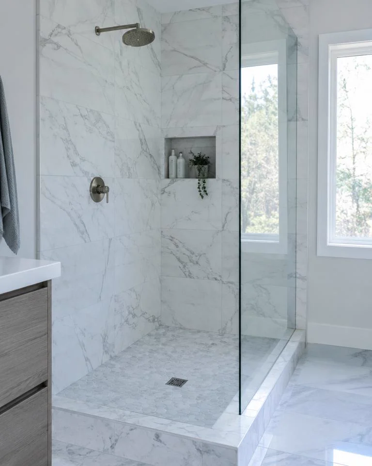 Walk-in shower with marble-look tile and glass panel